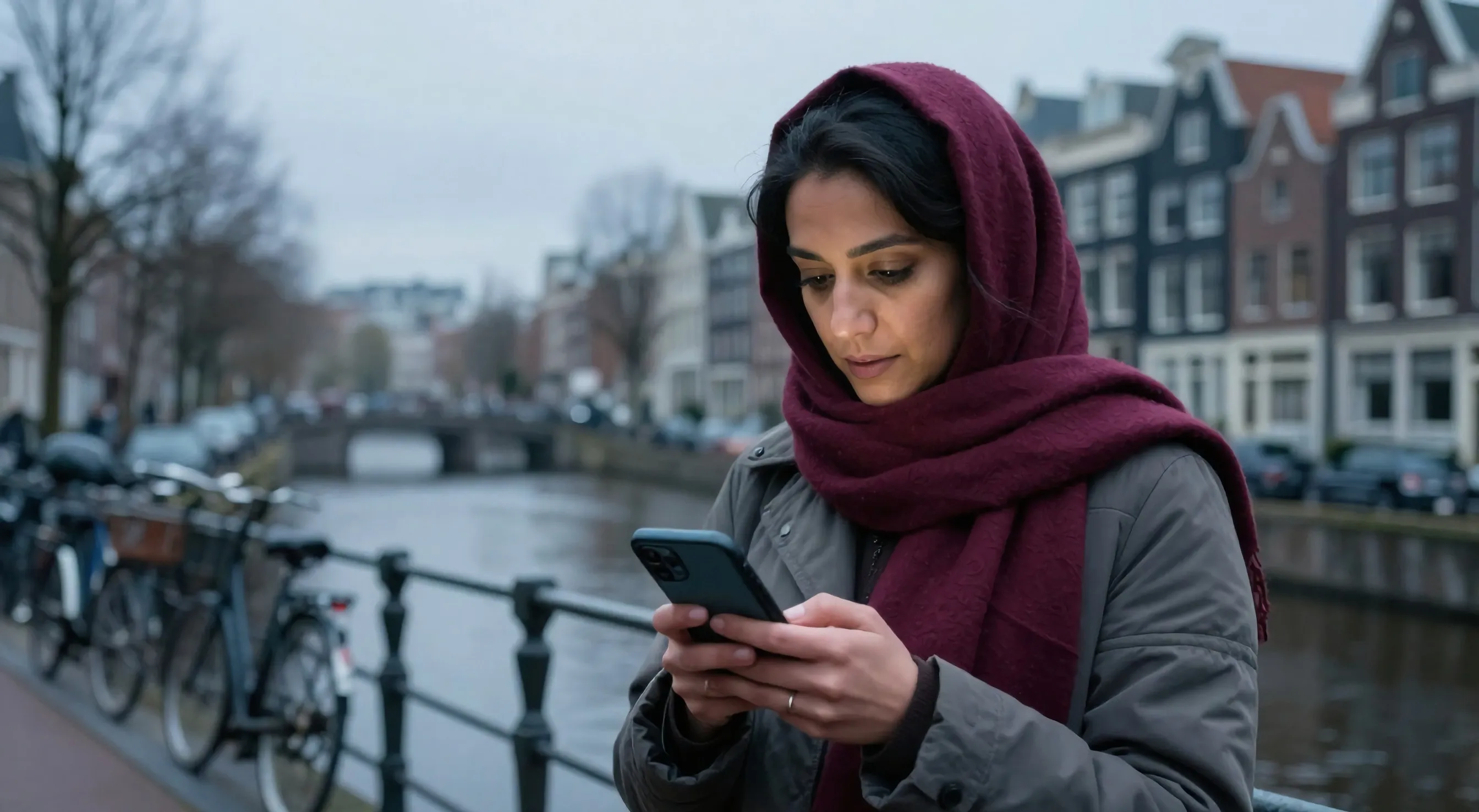 Marocaine à Amsterdam consultant son application de gestion immobilière sur son téléphone
